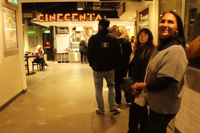 Attendees talking together in the lobby beneath the Cinecenta sign