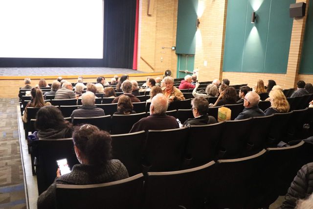 A seated cinema audience viewed from the back of the auditorium